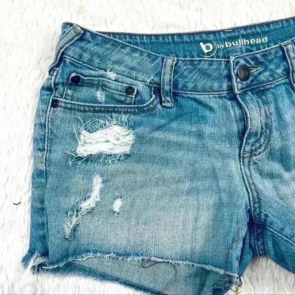 B By‎ Bullhead Med Wash Lowrise Distress Faded Cheeky Raw Hem Jean Shorts Size 9